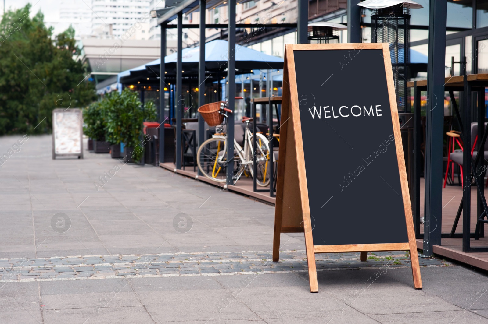 Image of Advertising board with word Welcome near restaurant outdoor terrace