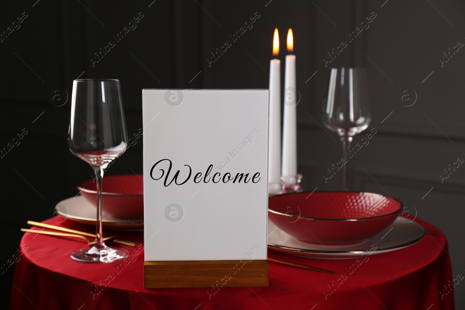 Image of Holder with word Welcome on table set for couple in restaurant