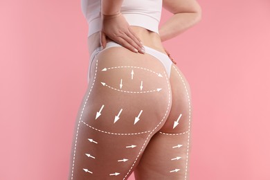 Image of Liposuction. Woman showing her figure against pink background, closeup. Markings on her body