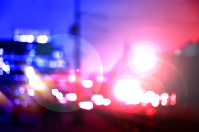 Image of Police red and blue lights in city, blurred view
