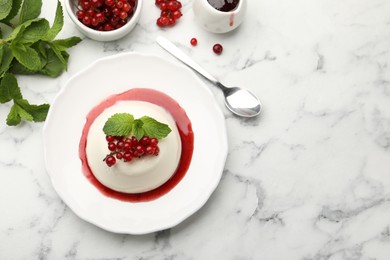 Photo of Delicious panna cotta with red currants, sauce and mint on white marble table, flat lay. Space for text