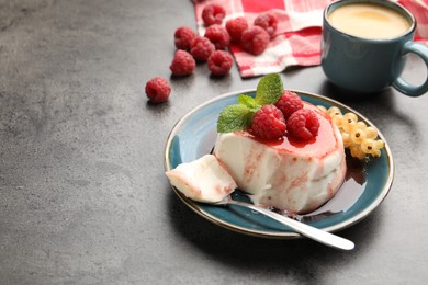 Photo of Delicious panna cotta with berries, sauce and mint on grey textured table, closeup. Space for text