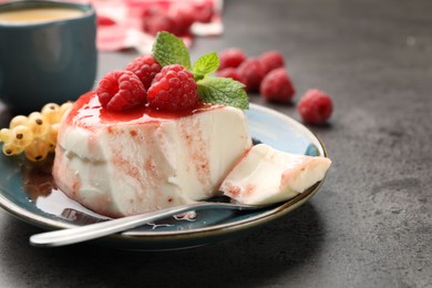 Photo of Delicious panna cotta with berries, sauce and mint on grey textured table, closeup