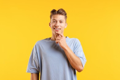 Photo of Dream come true. Positive young man thinking about something on yellow background