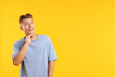 Photo of Dream come true. Positive young man thinking about something on yellow background. Space for text