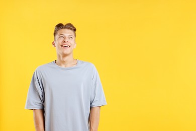 Photo of Dream come true. Positive young man thinking about something on yellow background. Space for text