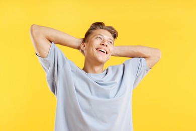 Photo of Dream come true. Positive young man thinking about something on yellow background