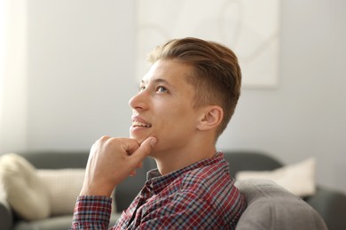 Photo of Dream come true. Positive young man thinking about something at home