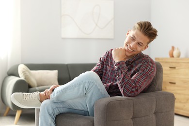 Photo of Dream come true. Positive young man thinking about something at home