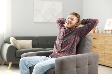Photo of Dream come true. Positive young man thinking about something at home