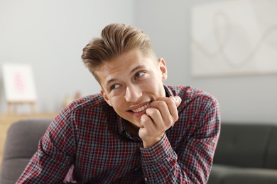 Photo of Dream come true. Positive young man thinking about something at home