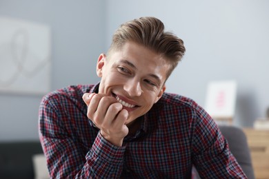 Photo of Dream come true. Positive young man thinking about something at home