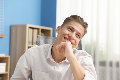 Photo of Dream come true. Positive young man thinking about something indoors