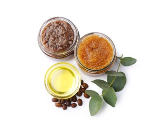 Photo of Natural body scrubs in glass jars, coffee beans, oil and eucalyptus branch isolated on white, top view