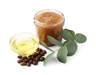Photo of Natural body scrub in glass jar, coffee beans, oil and eucalyptus branch isolated on white