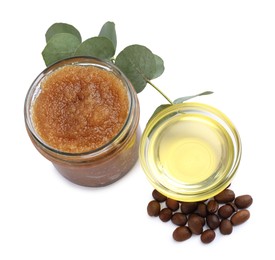 Photo of Natural body scrub in glass jar, coffee beans, oil and eucalyptus branch isolated on white, above view