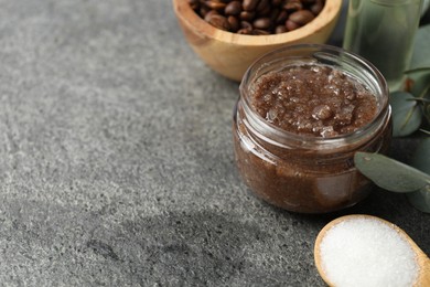 Photo of Natural body scrub in glass jar and ingredients on grey table, closeup. Space for text