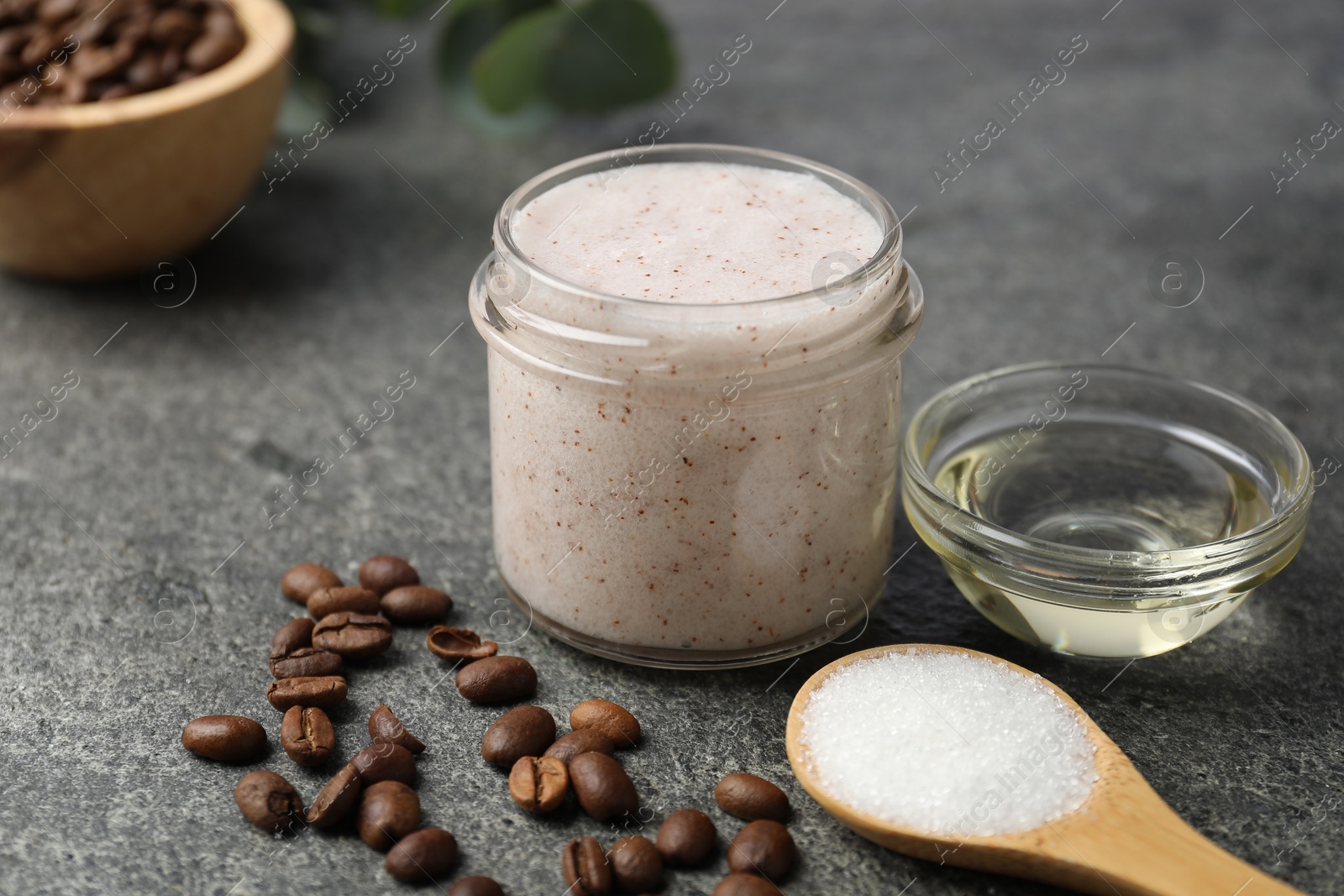 Photo of Natural body scrub in glass jar and ingredients on grey table, closeup
