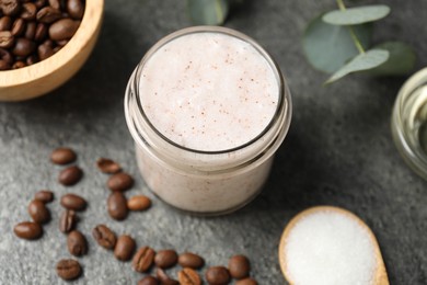 Photo of Natural body scrub in glass jar and ingredients on grey table, above view