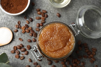 Photo of Natural body scrub in glass jar and ingredients on grey table, flat lay