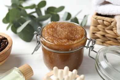 Photo of Natural body scrub, ingredients, brush and towels on white wooden table, closeup