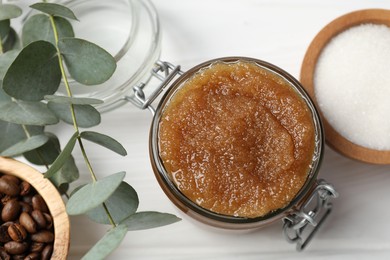 Photo of Natural body scrub in glass jar and ingredients on white wooden table, flat lay