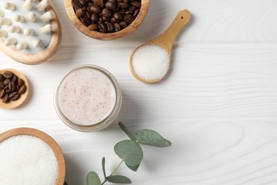 Photo of Natural body scrub in glass jar, ingredients and brush on white wooden table, flat lay. Space for text