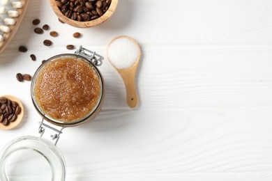 Photo of Natural body scrub in glass jar, ingredients and brush on white wooden table, flat lay. Space for text