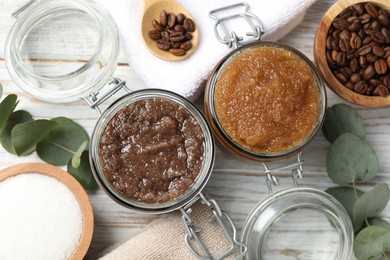 Photo of Natural body scrubs in glass jars and ingredients on wooden table, flat lay