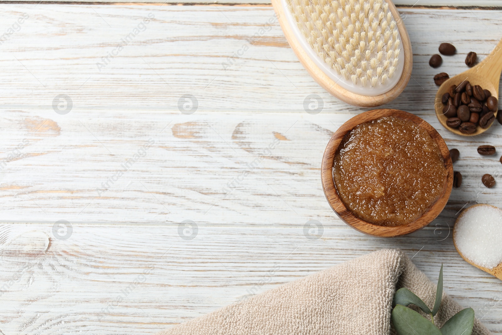 Natural body scrub in bowl, ingredients, brush and towel on wooden table, flat lay. Space for text Photo of Natural body scrub in bowl, ingredients, brush and towel on wooden table, flat lay. Space for text