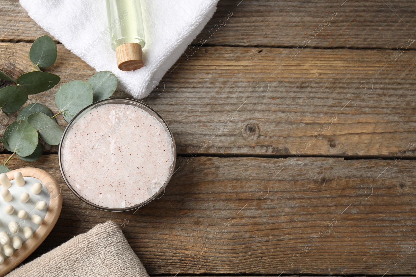 Photo of Natural body scrub in bowl, ingredients, brush and towels on wooden table, flat lay. Space for text
