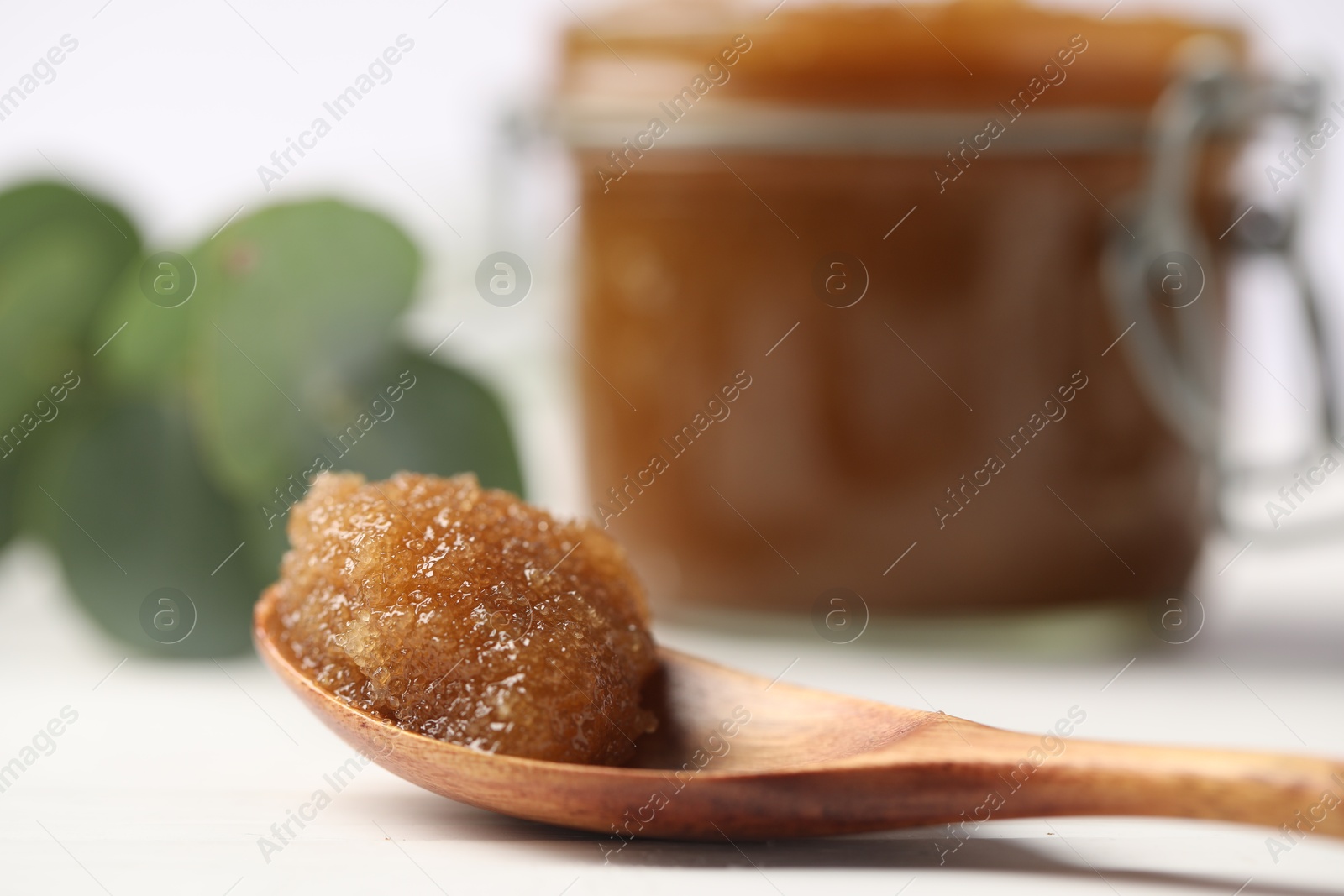 Natural body scrub in spoon on white table, closeup Photo of Natural body scrub in spoon on white table, closeup