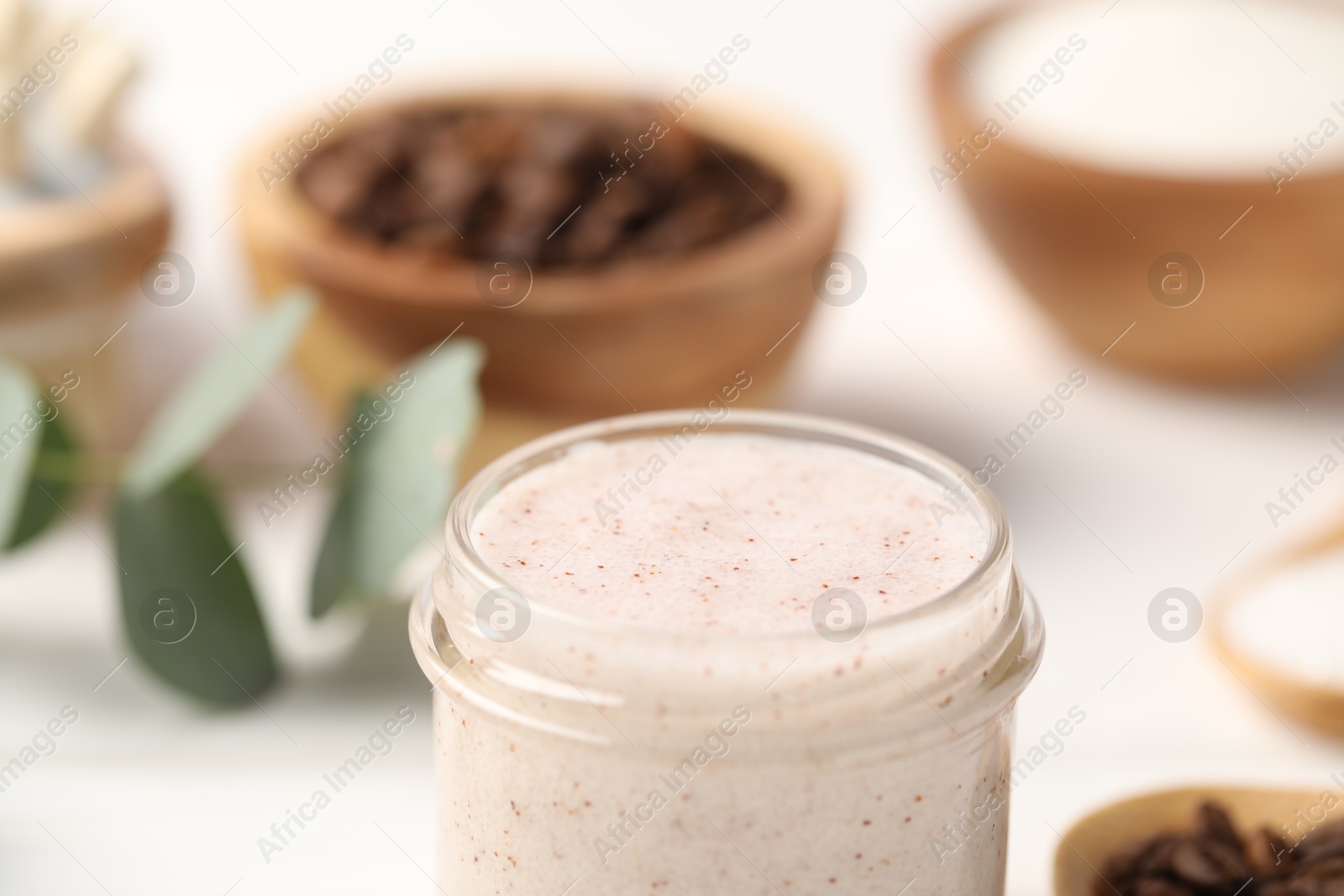 Natural body scrub in glass jar on blurred background, closeup Photo of Natural body scrub in glass jar on blurred background, closeup