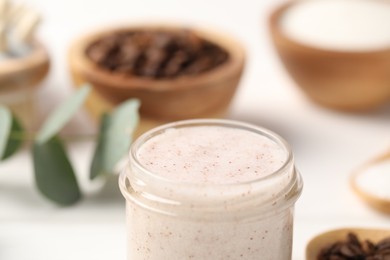 Photo of Natural body scrub in glass jar on blurred background, closeup