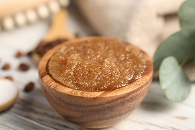 Photo of Natural body scrub in bowl on wooden table, closeup