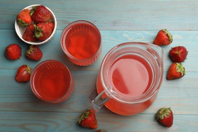 Photo of Tasty compot in glasses, jug and fresh strawberries on light blue wooden table, flat lay