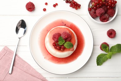 Photo of Delicious panna cotta with berries, sauce and mint on white wooden table, flat lay