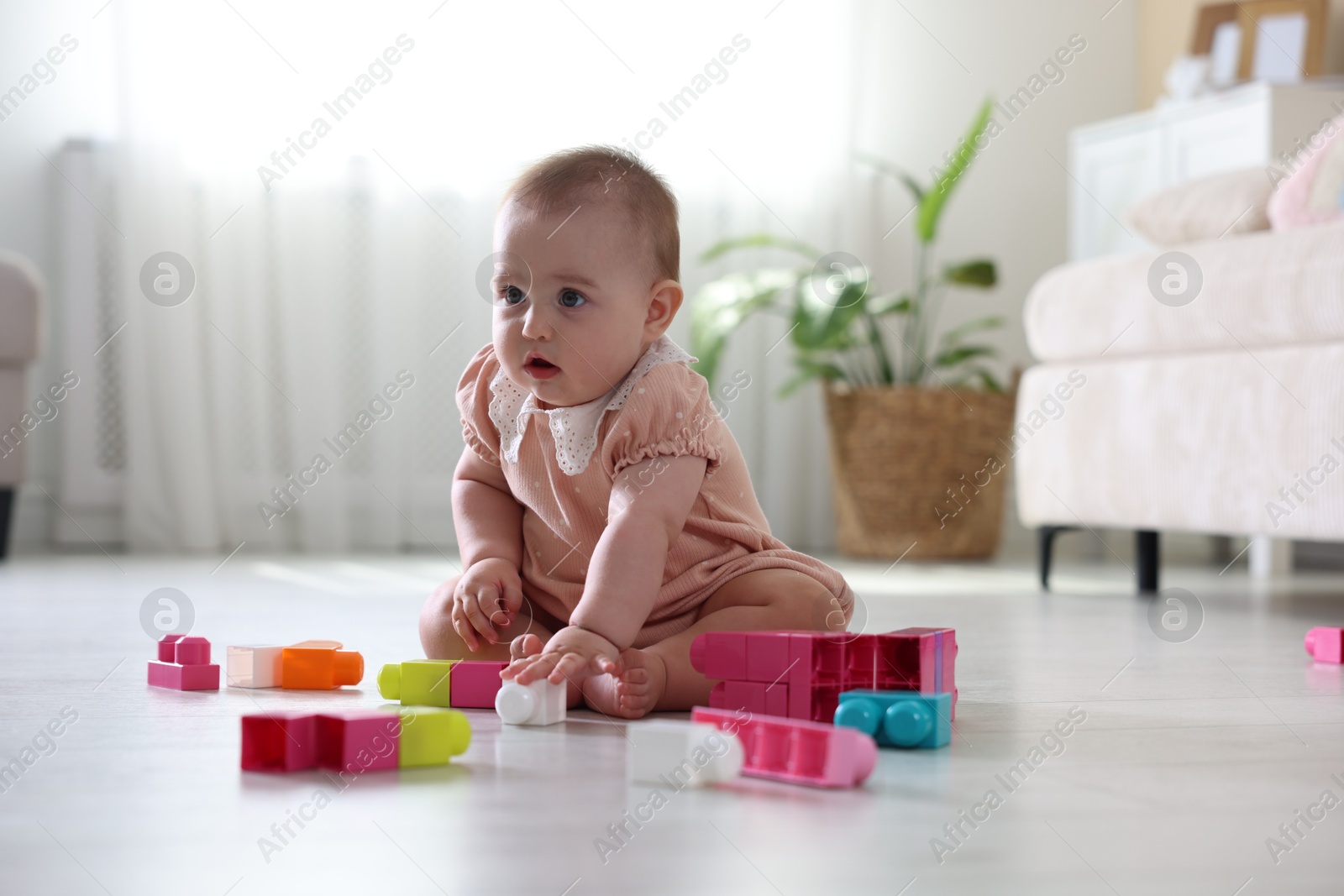 Cute little baby playing with toys on floor at home Photo of Cute little baby playing with toys on floor at home