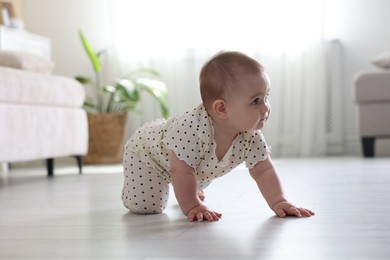 Photo of Cute little baby crawling on floor at home