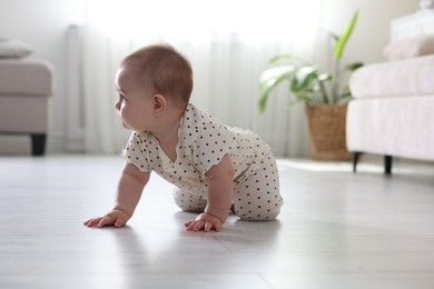 Photo of Cute little baby crawling on floor at home
