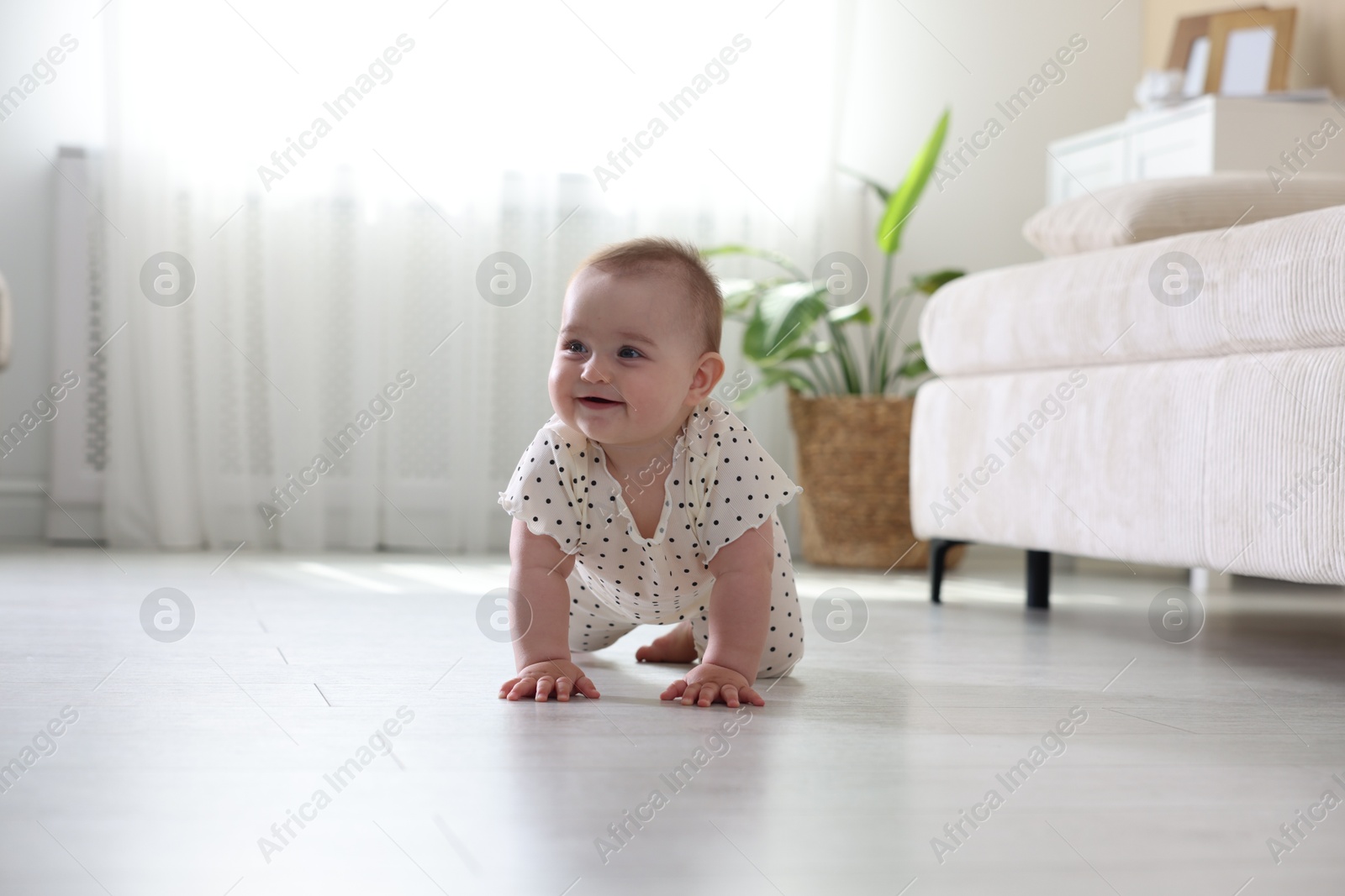 Cute little baby crawling on floor at home Photo of Cute little baby crawling on floor at home