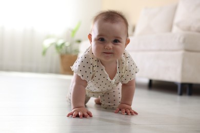 Photo of Cute little baby crawling on floor at home