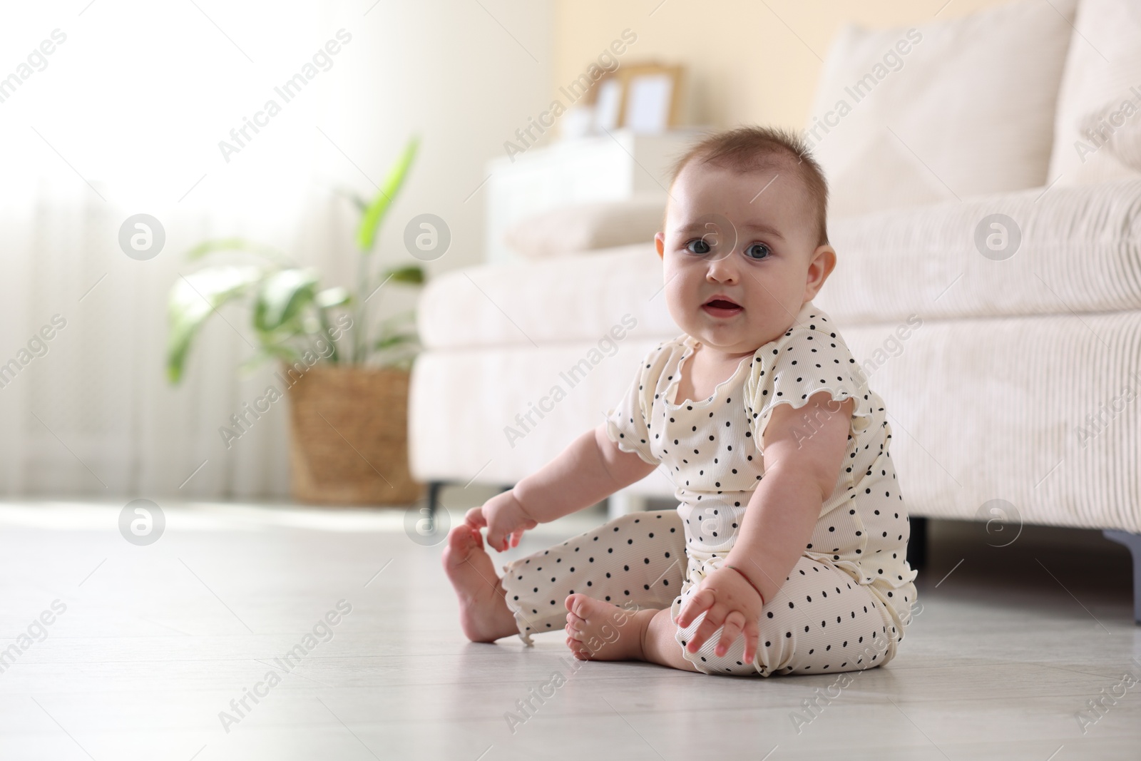 Cute little baby sitting on floor at home, space for text Photo of Cute little baby sitting on floor at home, space for text