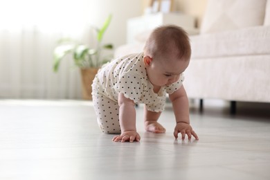 Photo of Cute little baby crawling on floor at home, space for text