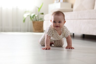 Photo of Cute little baby crawling on floor at home, space for text