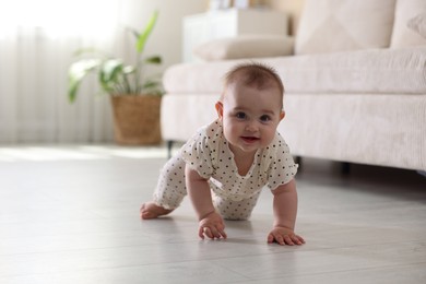 Photo of Cute little baby crawling on floor at home, space for text