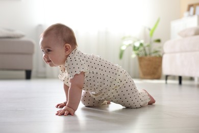 Photo of Cute little baby crawling on floor at home