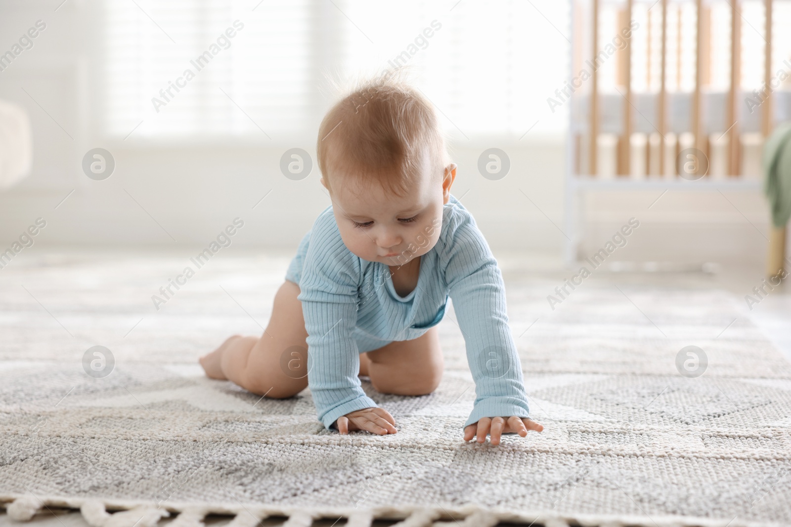 Cute little baby crawling on floor at home Photo of Cute little baby crawling on floor at home