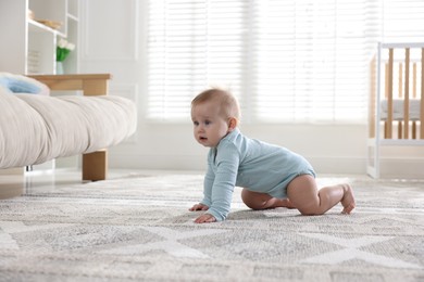 Photo of Cute little baby crawling on floor at home