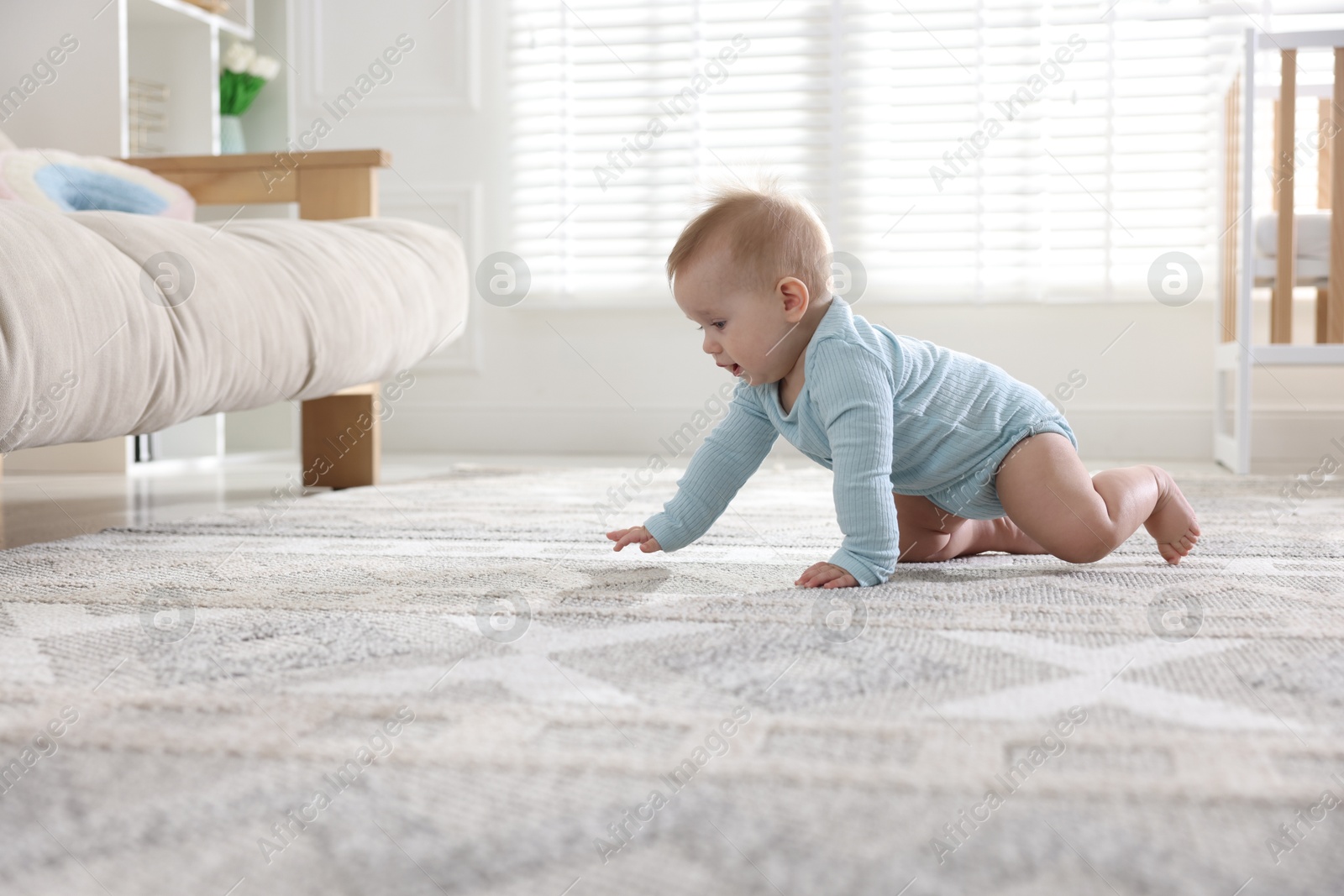 Cute little baby crawling on floor at home Photo of Cute little baby crawling on floor at home